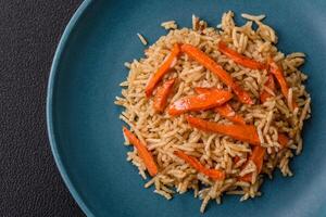 Delicious fresh pilaf with rice, carrots, meat, onions, spices and berries photo