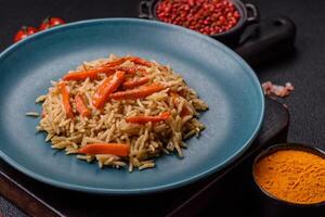Delicious fresh pilaf with rice, carrots, meat, onions, spices and berries photo