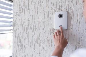 Close-up photo. The finger of a man's hand presses the button of the incoming call of the door, the camera. Electric lock to office, home, delivery. photo