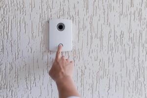 Close-up photo. The finger of a man's hand presses the button of the incoming call of the door, the camera. Electric lock to office, home, delivery photo