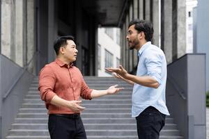An intense exchange between two colleagues on office stairs captures a moment of workplace conflict. The image reflects emotions such as anger and stress, highlighting professional disagreements. photo