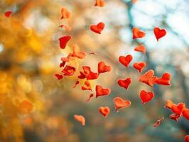 Red hearts falling through autumn bokeh. photo