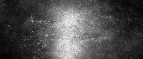 Dark grunge texture featuring subtle scratches and a luminous central highlight, perfect for backgrounds. photo