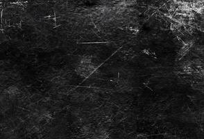 Dark scratched black grunge texture with rough distressed elements, perfect for backgrounds or digital overlays. photo