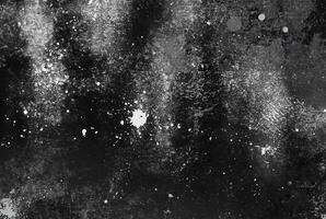 A dark abstract texture with white splatter and streak patterns, evoking a gritty and dramatic artistic effect. photo