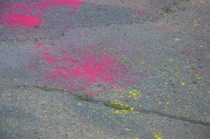 Bright colored spots of powder paint on the asphalt. photo