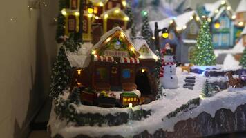 A Charming Winter Village Scene featuring a Snowman adorned with Festive Lights and Decorations video