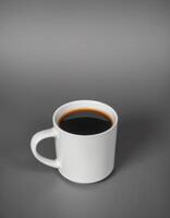Warm cup of black coffee resting on a smooth gray surface in a calm setting photo