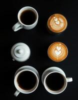 Enjoying a cozy coffee break with beautifully crafted lattes and rich black coffee on a dark surface photo