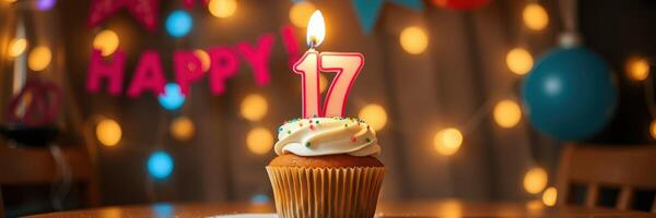 Celebratory cupcake with 17 candle and festive decorations during a birthday gathering photo