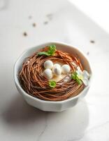 Delicious dessert in a decorative bowl resembling a bird's nest with chocolate and white candy eggs photo
