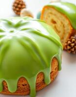 Delicious green glazed cake garnished with decorative elements and fruit on a white surface photo