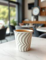 Warm cup of coffee resting on a marble table in a modern cafe setting during the afternoon photo