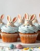 Cute bunny cupcakes decorated with pastel frosting and candy in a bright setup for a festive occasion photo