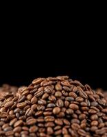 Coffee beans piled high in a dark setting showcase freshness and rich aroma, perfect for brewing flavorful beverages with intensity photo