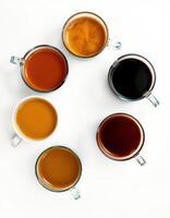 Different types of coffee served in glass cups arranged in a circular pattern on a white surface photo