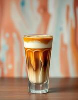 Creamy coffee drink served in a tall glass against a colorful backdrop in a cozy cafe photo