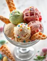 Colorful ice cream scoop selection served in a glass bowl with candy sprinkles and waffle cones photo
