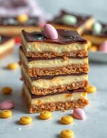 Delicious layered dessert with creamy filling and chocolate topping served with colorful candies photo