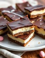 Delicious layered chocolate dessert with creamy filling and crumbly base displayed on a plate with pastel candies photo