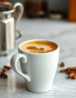 Warm cup of coffee with latte art beside cinnamon sticks on a marble surface photo