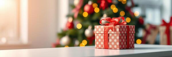 Holiday gift box on a table with Christmas tree and lights in the background during festive season photo