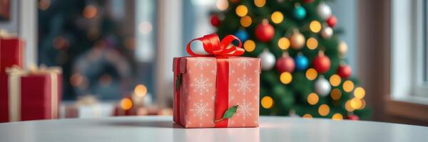 A beautifully wrapped gift placed on a table in front of a decorated Christmas tree with colorful lights and ornaments in a cozy setting photo
