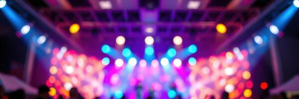 Colorful lights illuminate a lively music event at an indoor venue during the evening photo