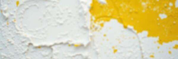 White and yellow textured wall with peeling paint revealing layers of colors and materials over time photo
