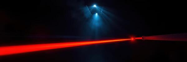 Vibrant red laser cutting through darkness with blue spotlights illuminating the surrounding space during a nighttime event photo