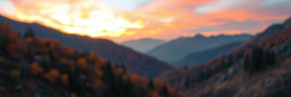 Sunset over mountain valleys creates vibrant hues in the sky amid beautiful autumn foliage and distant peaks photo