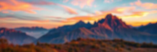 Sunset panorama over mountains with vibrant sky and soft clouds during early evening hours photo