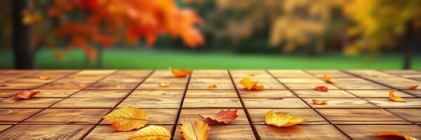 Colorful autumn leaves scattered on wooden deck with vibrant trees in the background creating a serene outdoor atmosphere photo