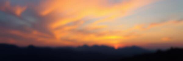 Stunning sunset over mountain range with vibrant hues and soft clouds in the sky creates a serene atmosphere photo