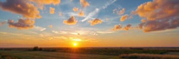 Sunset over an open field with colorful clouds and a serene atmosphere in the early evening photo