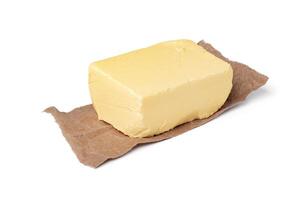 Fresh butter on craft paper isolated on white background photo