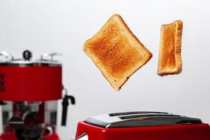 Two toasts jumping out of red toaster against white background photo