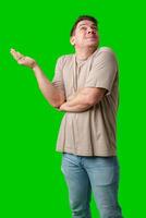 A person smiling and gesturing with hands in front of a bright green backdrop photo