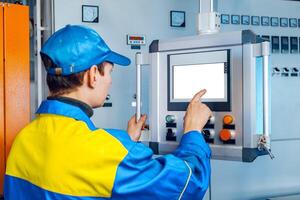 Man worker in manufacturing plant at cable factory machine control computer panel photo