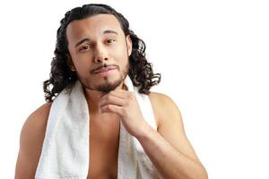 Smiling man with curly hair showing confidence while holding a towel photo