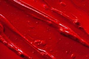 Red lipstick background texture smudged. Close up. photo