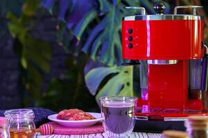Red coffee machine with a glass on kitchen counter photo