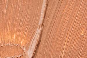 Background of a smudged cream foundation texture photo