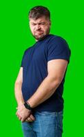 Man expressing confusion with crossed arms in front of a bright green background photo