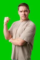 Man celebrating with a confident smile and raised fist against a bright green background photo