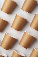 A collection of disposable paper cups arranged in a repeating pattern on a light background photo