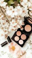 Makeup products surrounded by soft floral arrangements create a serene beauty display on a clean surface photo
