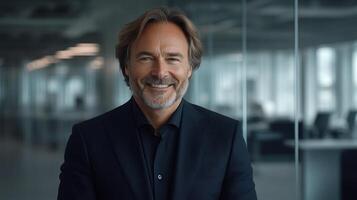 A man with a friendly demeanor displays confidence while seated in a contemporary office photo
