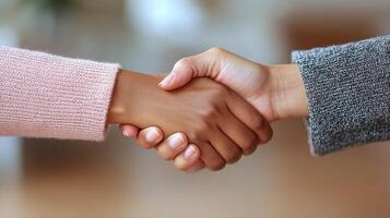 Two individuals shake hands in a cozy environment, symbolizing agreement and collaboration photo