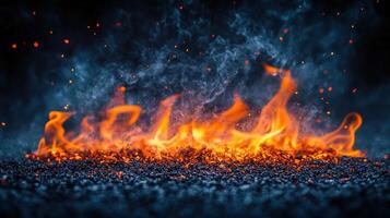 Bright orange flames swirl and flicker over a dark textured surface, showcasing a mesmerizing display of fire photo